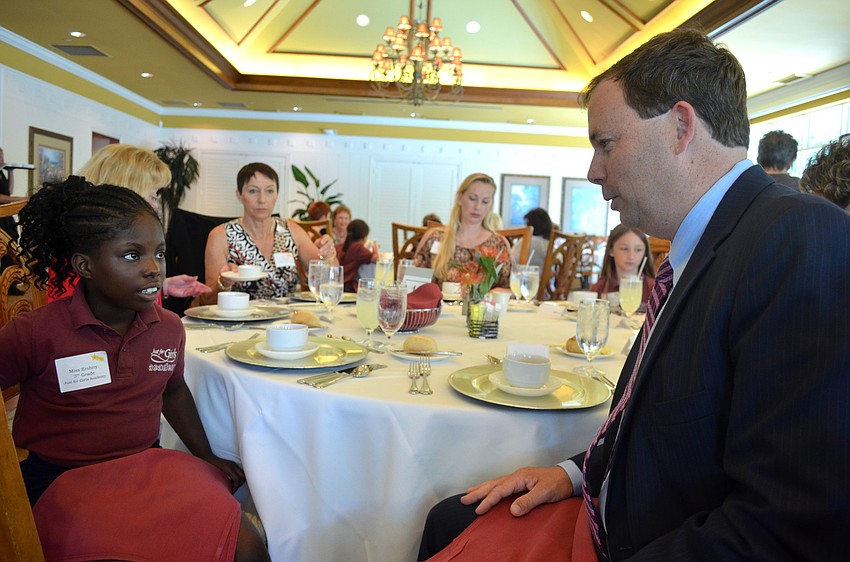 Ershny Edmond shows John Neal how to properly place his napkin on his lap.