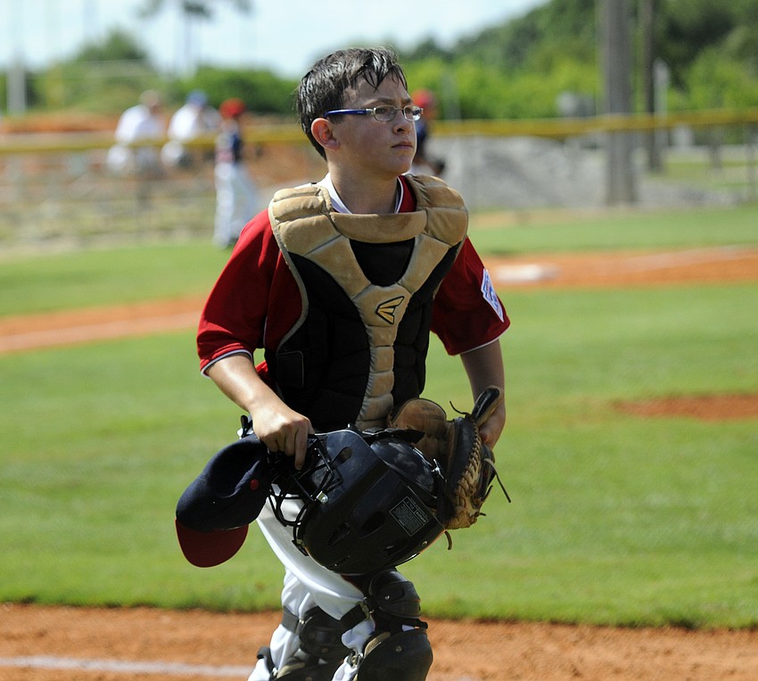 Sarasota American 10/11 All-Star catcher Kyle Upman trots off the field after his team recorded the final out of the inning.