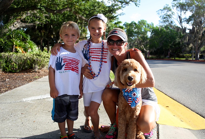 Macklin and Callie Higgins smile next to their mother, Lisa, and their pup, Mango.