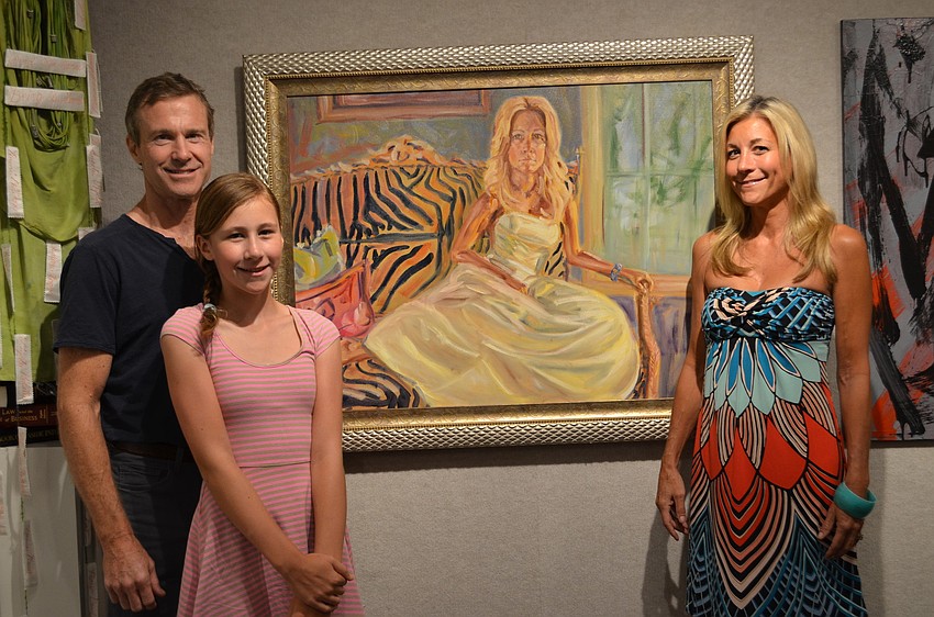 Artist Bix Mannion, daughter Grace Mannion and wife/model Gretchen Mannion pose in front of the portrait Bix painted of Gretchen. She did two sittings of 3-hours each.