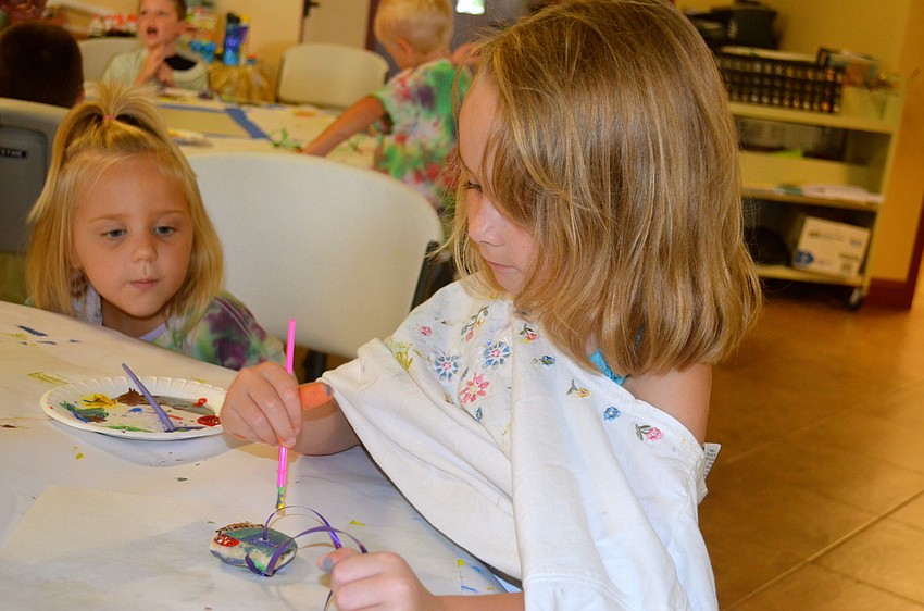 Isabella Brown paints a sand dollar during craft time.