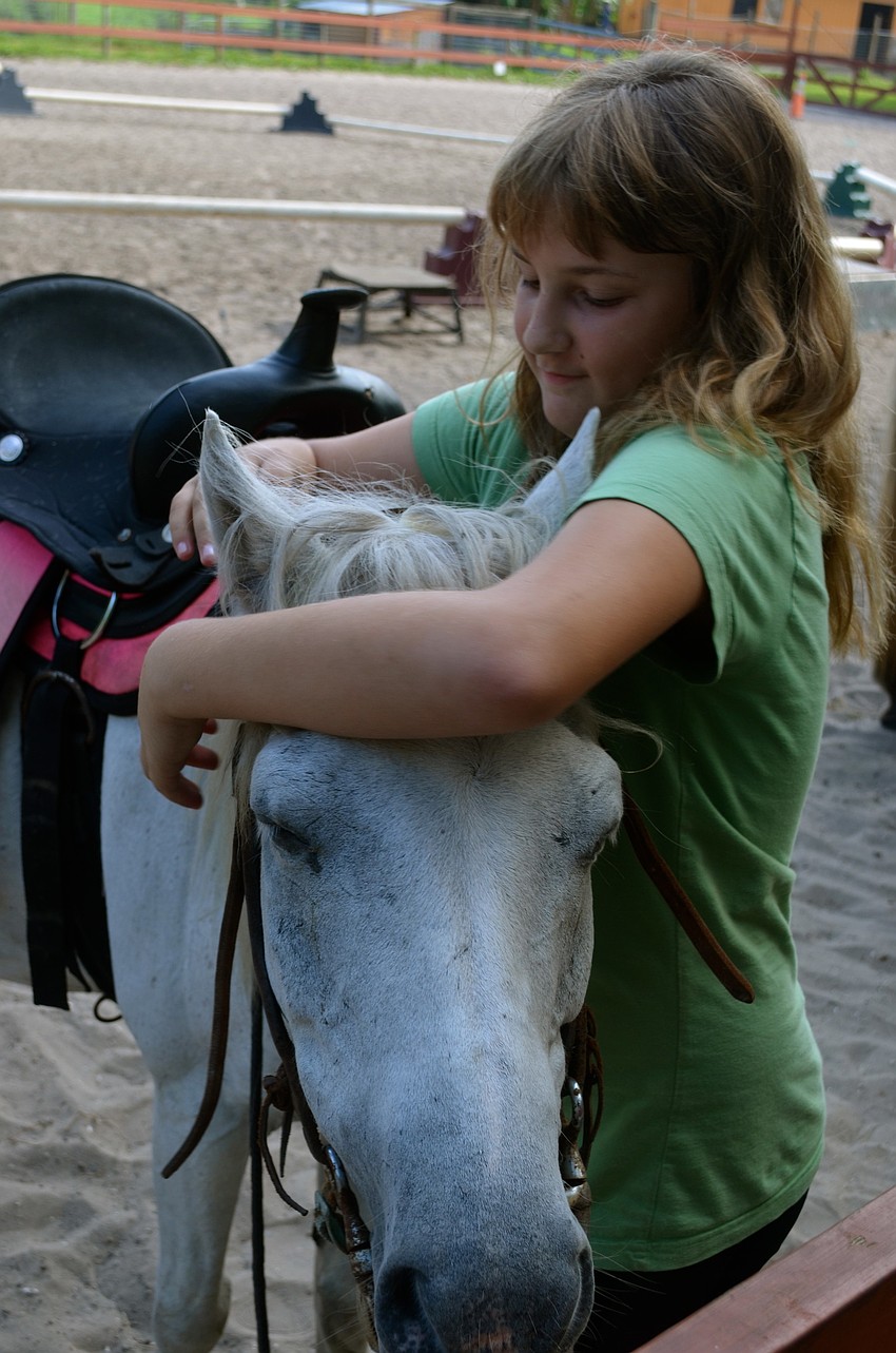 Ten-year-old Miriam Baram gets Morning Glory ready for a ride.