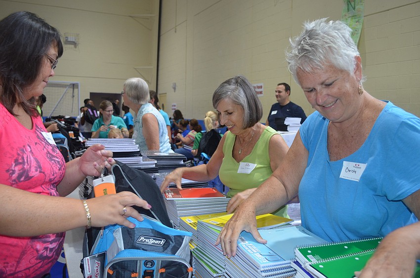 Sharon Dickman and Chrisy Deohanan hand Sheryll Unwin with notebooks.