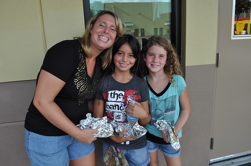 Natalie and Alexcia Rodriguez eat hot dogs with Grace Turcotte.