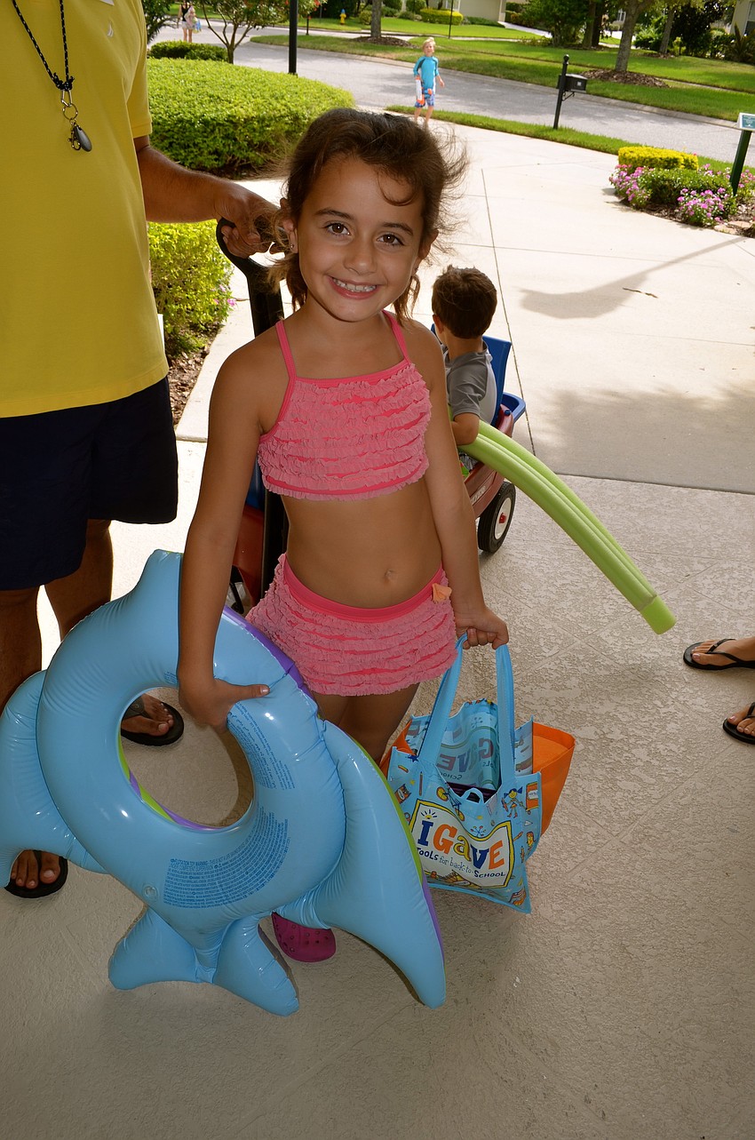 Seven-year-old Olivia Ajrab carries school and pool supplies.
