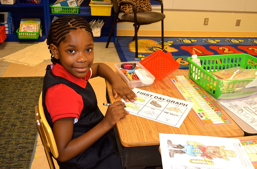 Jassee Alexis colors a picture at her new desk.