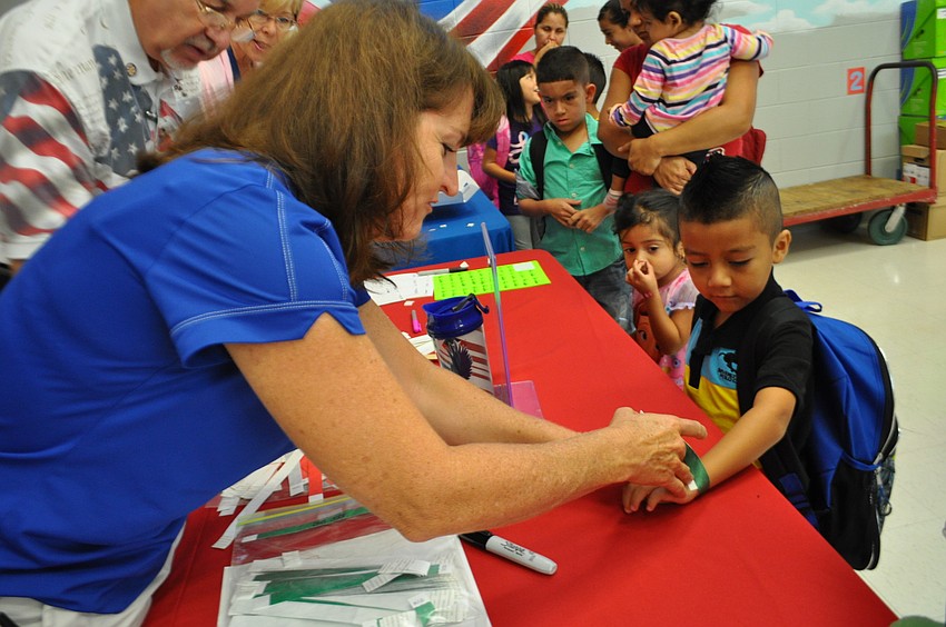 Social Worker Valerie Morrison tags Angel Escamilla with a wristband denoting how he will get home.