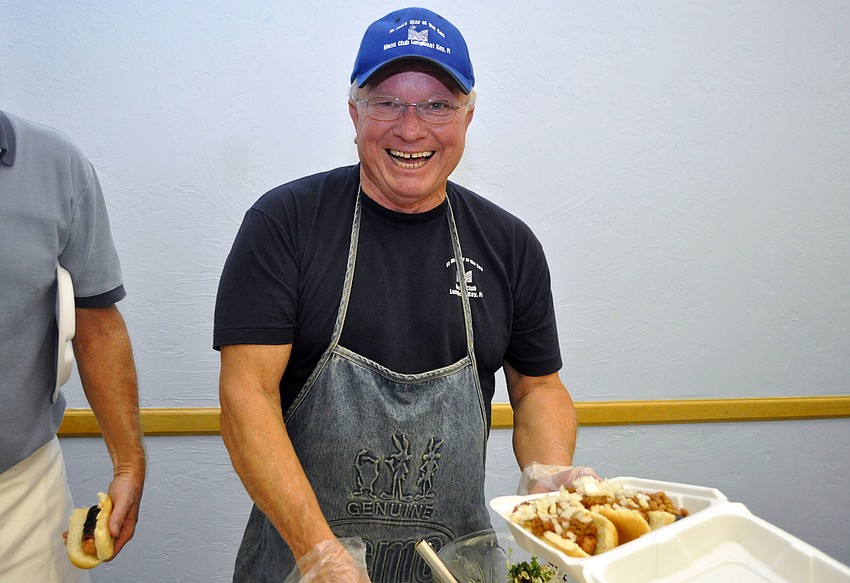 St. Mary Star of the Sea Menâ€™s Club president Dave Carter fixes some jersey style hot dogs to go.