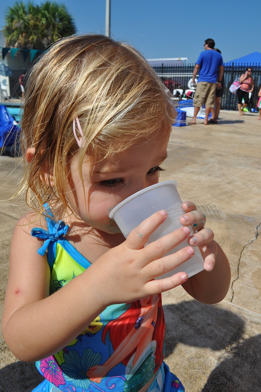 Brynn Heyman guzzles water at the East County Observer booth.