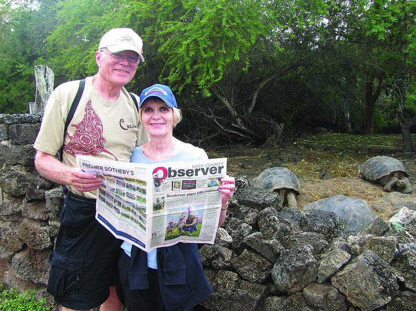 TURTLE POWER. Bob and Marcy Krambeck share their Observer news with a few giant tortoises at the Charles Darwin Research Center on Santa Cruz Island in the Galapagos Islands.