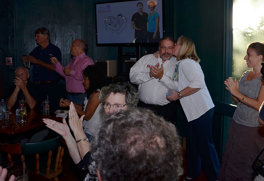 Amid applause, Nancy Maio kisses her husband on the cheek as the precinct counts rolled in Tuesday night and showed Alan in the lead.