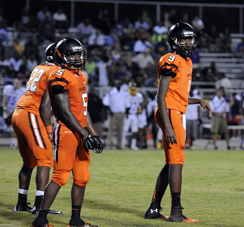 Sarasota running back Justin Austin and quarterback Xakari Hawkins receive a play from the sideline in the second quarter.