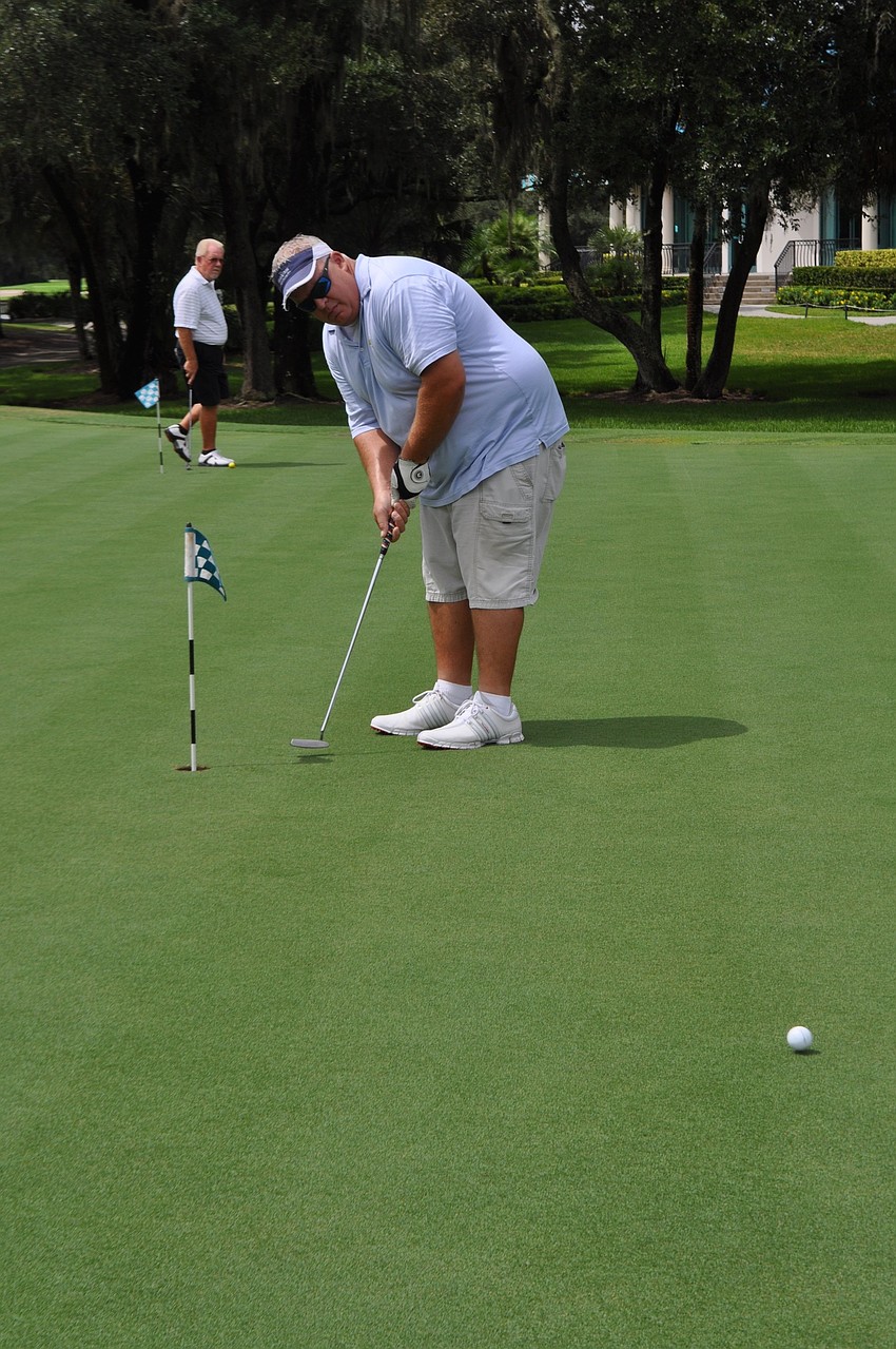 Rocky Purvis goes for a long practice putt.