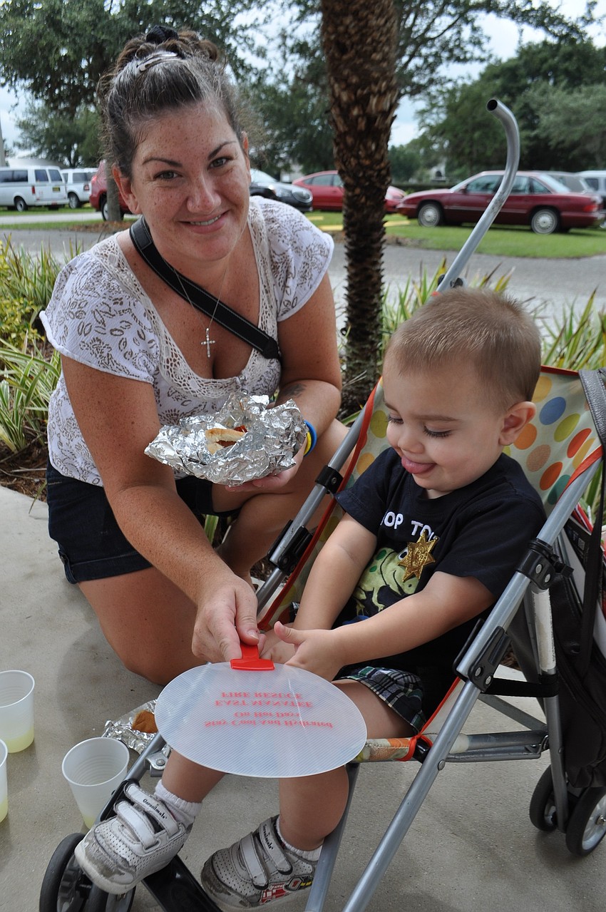 Ashley Pendrod and her son, Lucas, enjoy hot dogs.