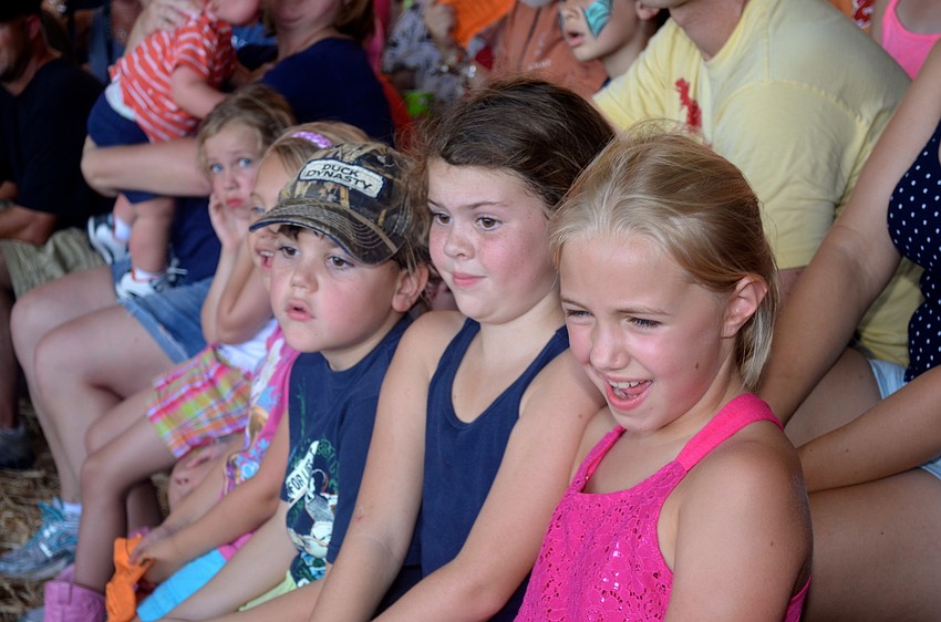 Luke and Allie Fredenburg, and Abby Jones watch the lumberjack show.