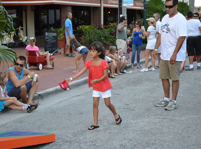 Gabriella Salgado and her father Francisco take turns playing a game of corn hole.