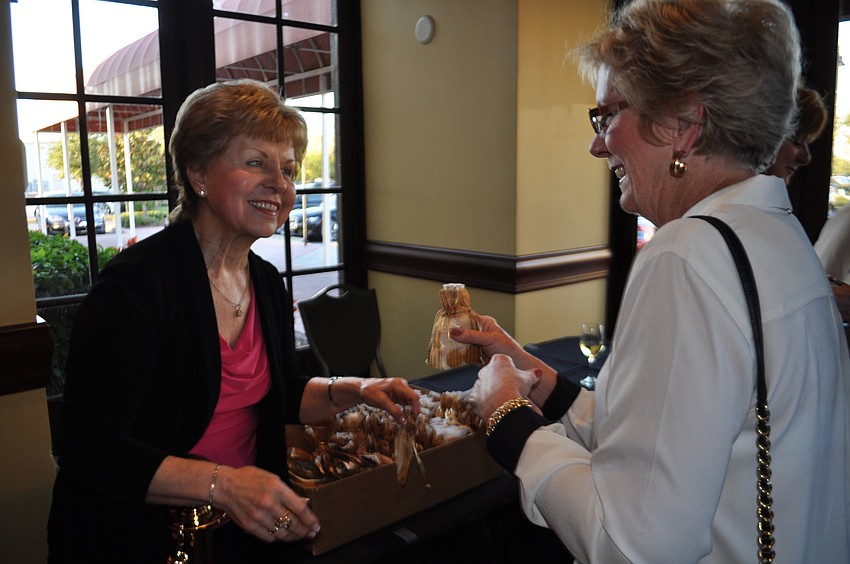 Marylee Danahy gives a gift bag to Kate Langsen as she enters the event.