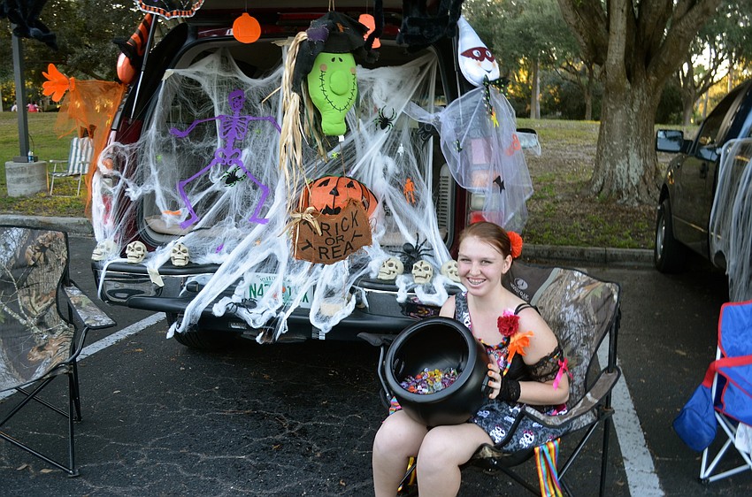 Asa Webb hands out candy near the back of her SUV.