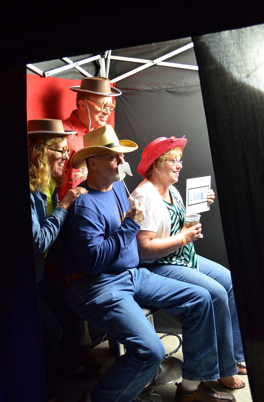 Deb and Dave Cattani pose with friends Patsy and George Peterson in the photo booth with props.