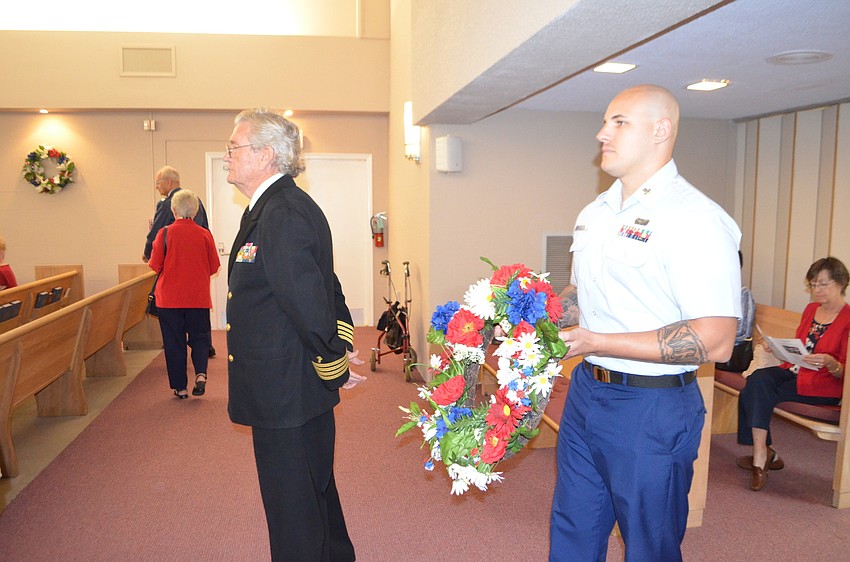 Rev. Dr. Vincent Carroll and Erik Pierantoni of the U.S. Coast Guard prepare to proceed down the aisle for a memorial wreath presentation.