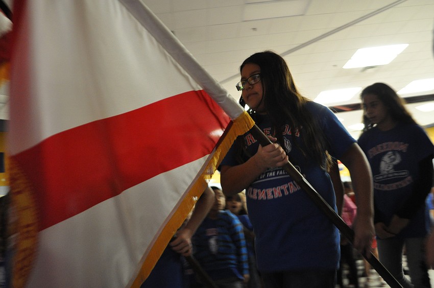 SOAR Ambassador Zenadie Mireles serves as a color guard at the start of the ceremony.