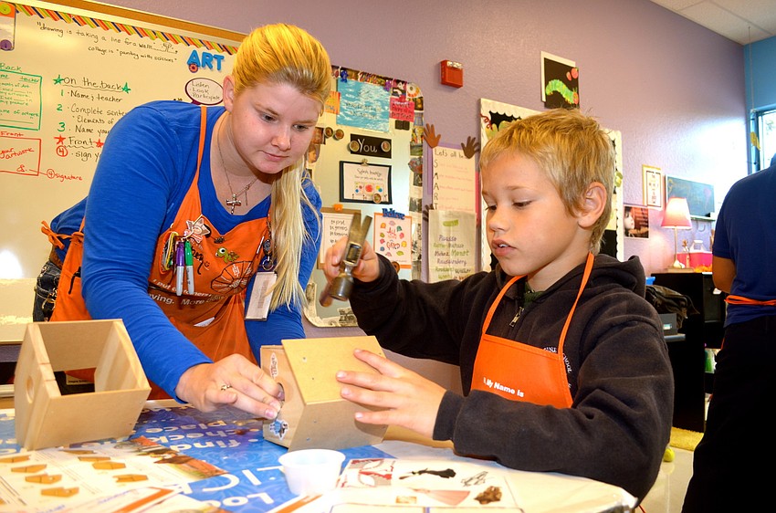 Home Depot employee Amber Mott helps Jackson Perry construct his 