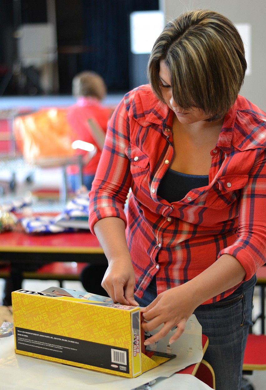 Josie Ludrigue helps wraps gifts at Girls Inc. for the Project Santaâ€™s Helpers.