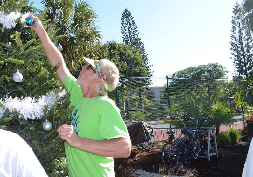 Pat Thompson puts an ornament on the tree.