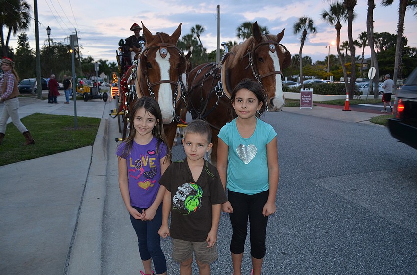 Leisa Wilhelm, 7, with siblings Easton, 4, and Illiana, 9, pose in front of horses, Rowdy and Cody.