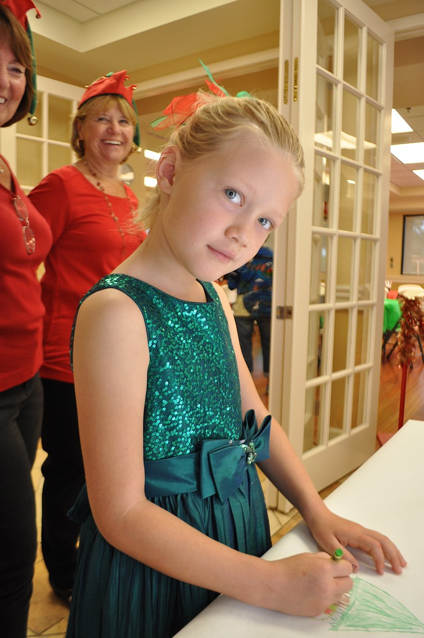 Sara Martin, 6, draws a Christmas tree.
