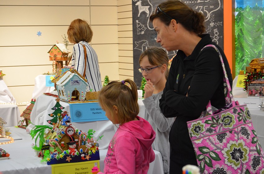 Kristin Domian with her daughters Addyson and Kate check out the gingerbread houses at the Gingerbread Festival.