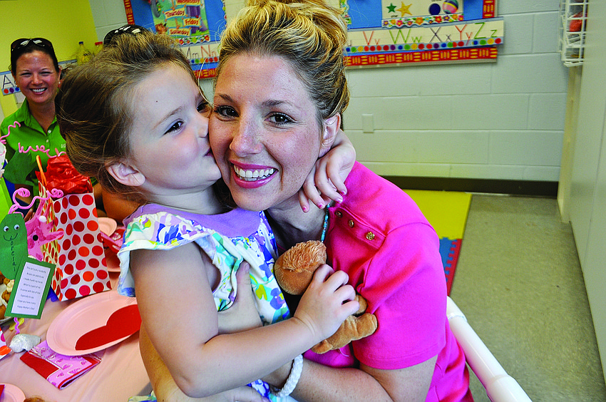 Lorelai Kelley, 4, gives her mom, Janeen, a kiss before a Mother's Day breakfast at All God's Children.