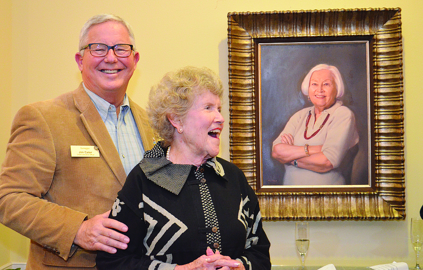 Jim Cater, president and CEO of Praxeis, and Jackie Pillsbury celebrate the unveiling of a portrait of the late Mary Fran Carroll at The Glenridge on Palmer Ranch.