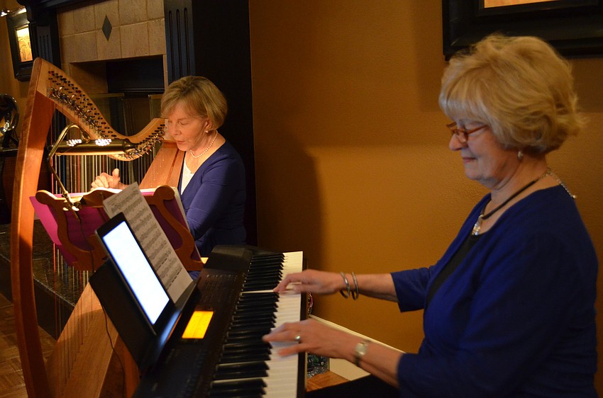 Shari Burau and Pat Howlett perform on the harp and keyboard.