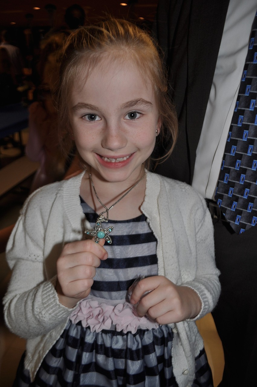 Paige Blenker, 7, shows off the new necklace her father, John, gave her.