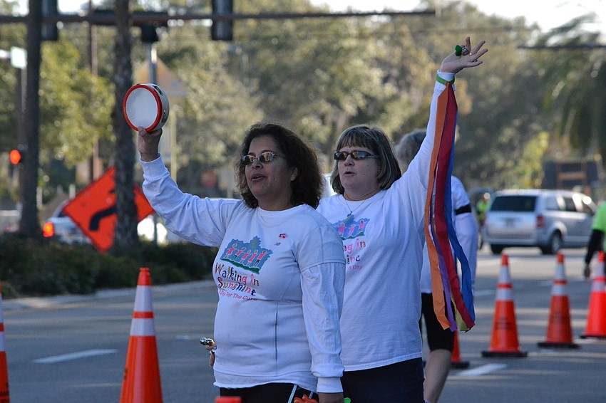 Lisa Amira and Theresa Heinis wave and cheer for runners.