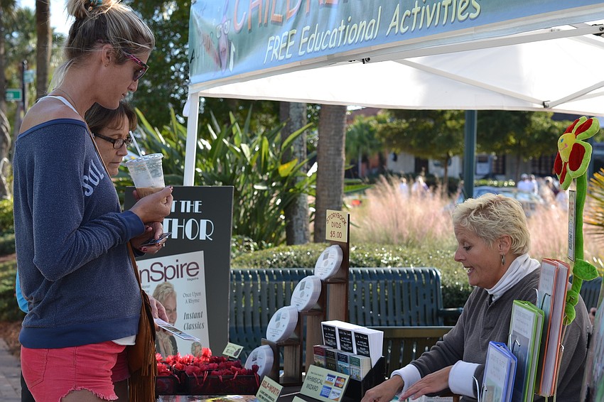 Megan and Claire Brockway talk with author Julie Woik at the Siesta Key Craft Festival.