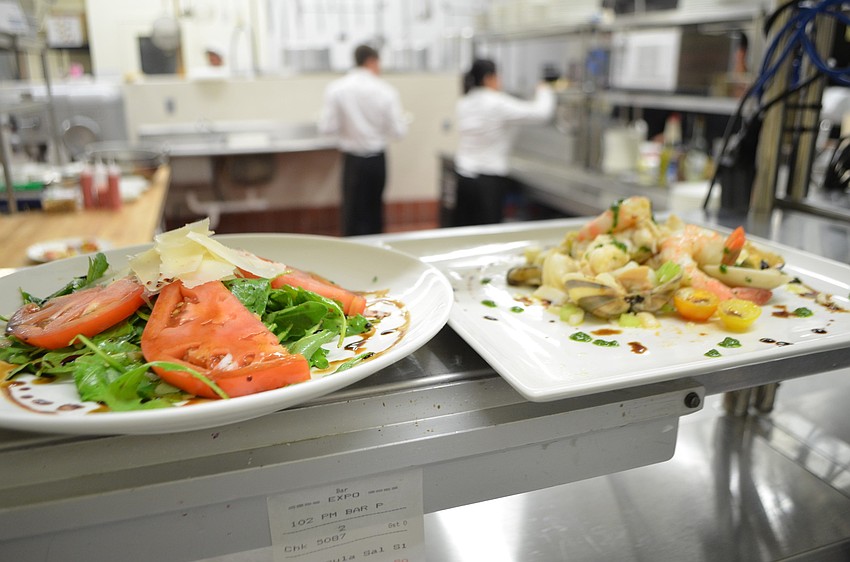 The arugula and seafood salads wait to be served.
