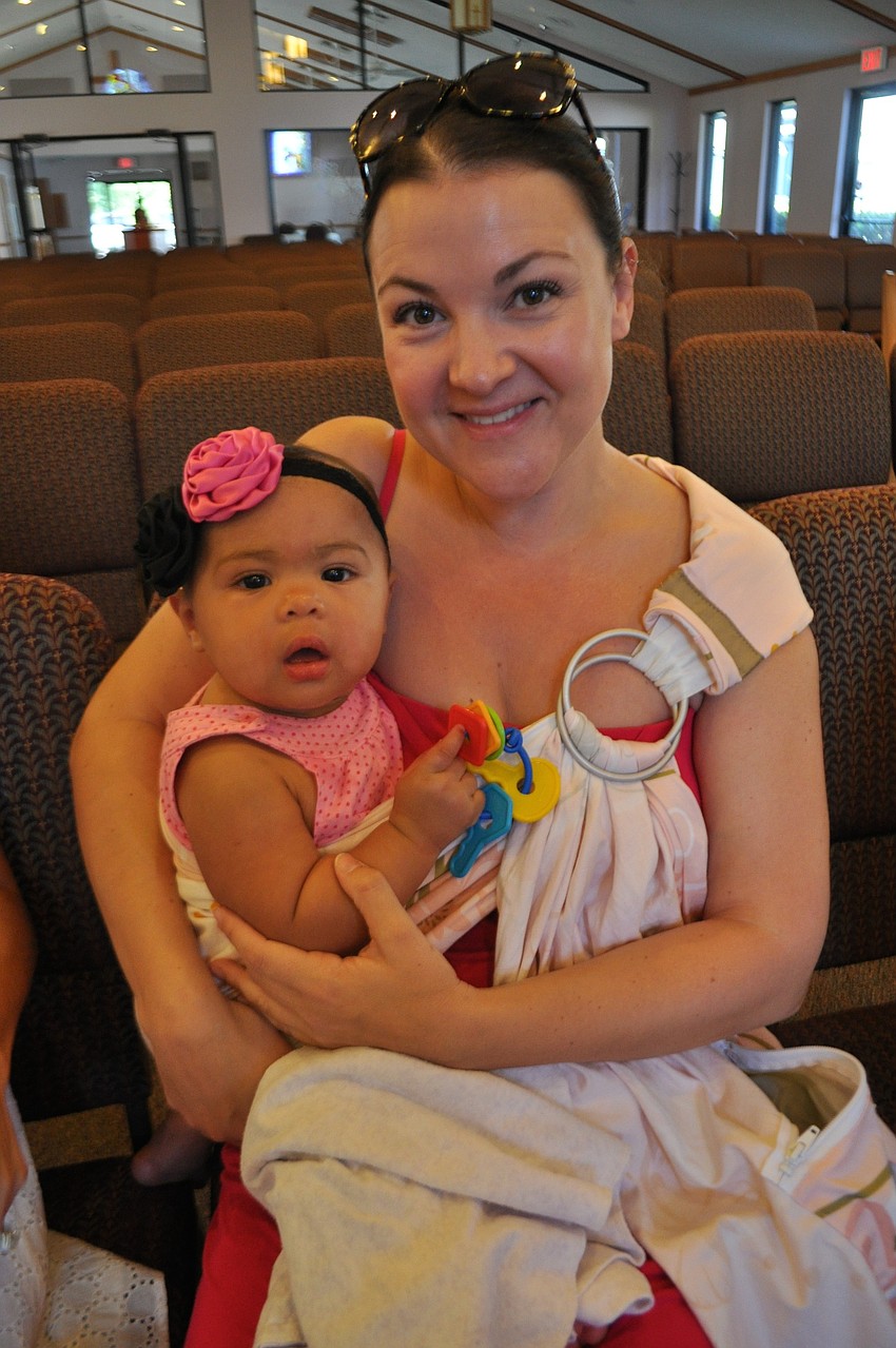 Carrie McQueen, with her daughter Jaden, waits for her daughter, Sienna, to participate in a ceremony.
