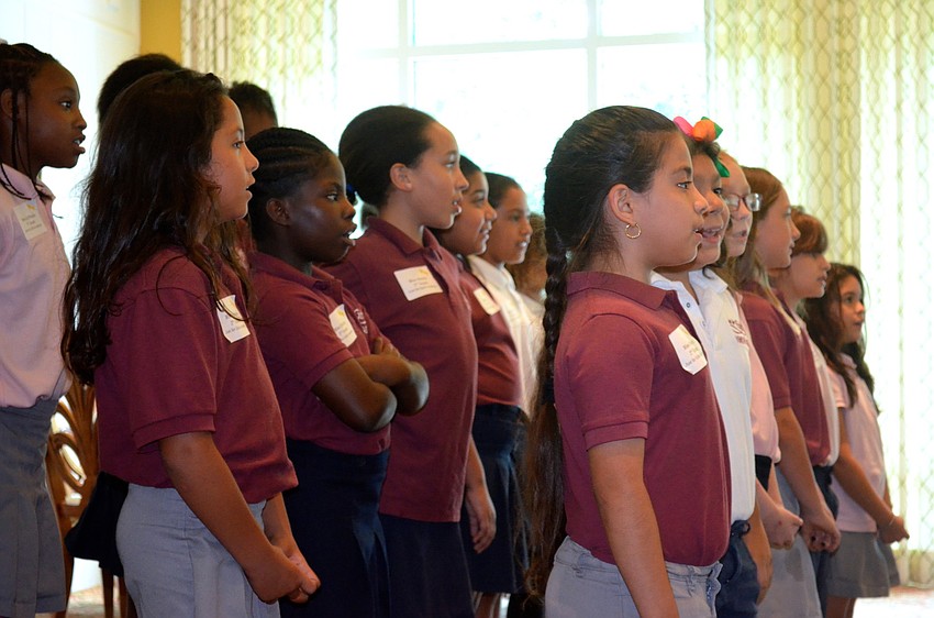 Third-grade Just for Girls Academy students sing songs for their audience.