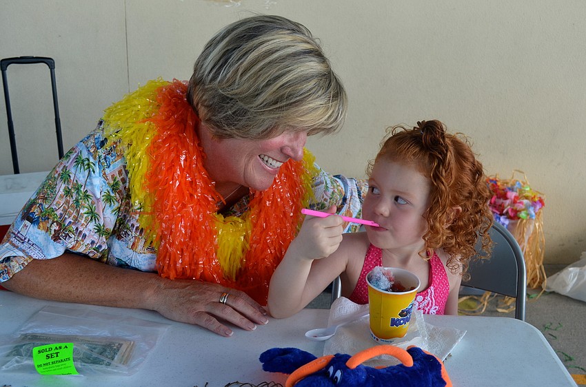 Sandy Jordan watches Vivianna Sprague snack on a frozen treat.