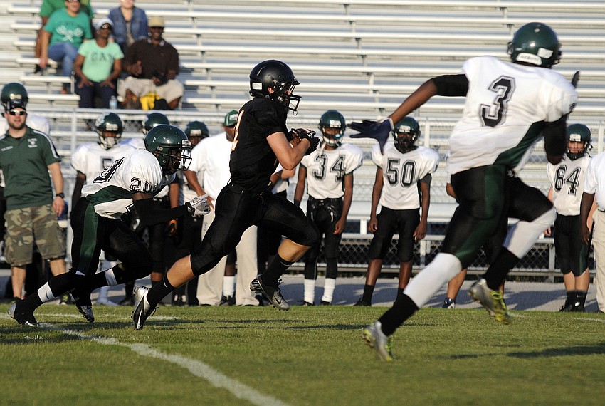 Sarasota running back Davis Gurr carries the ball for a first down.