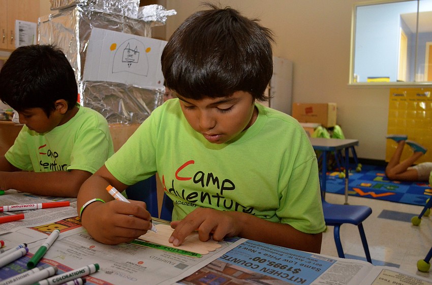 Amado Serrate, 9, colors popsicle sticks.