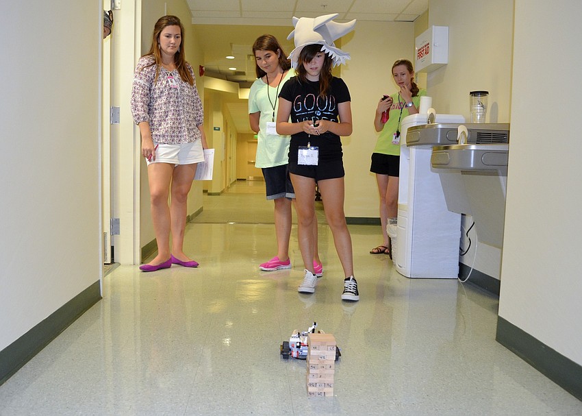 Bianca Shriver and her partner, Elizabeth Englander, demonstrate what their robot can do by knocking down a Jenga tower.