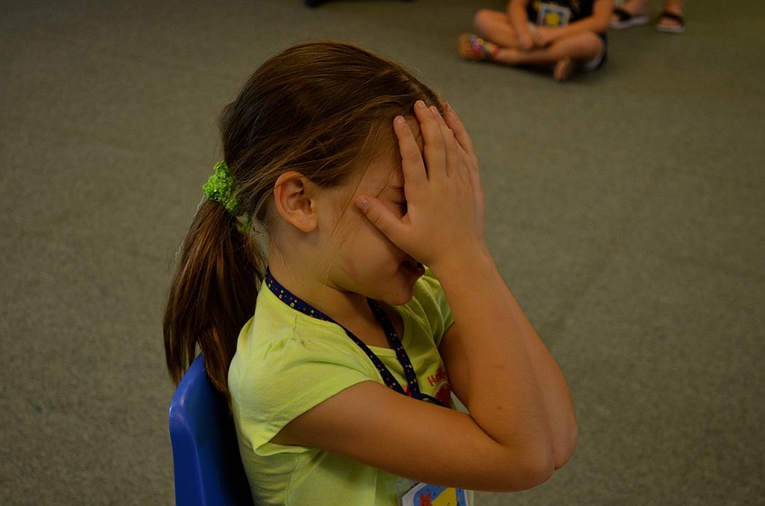 Grace Hroncich counts to 10 before searching for hiding students.