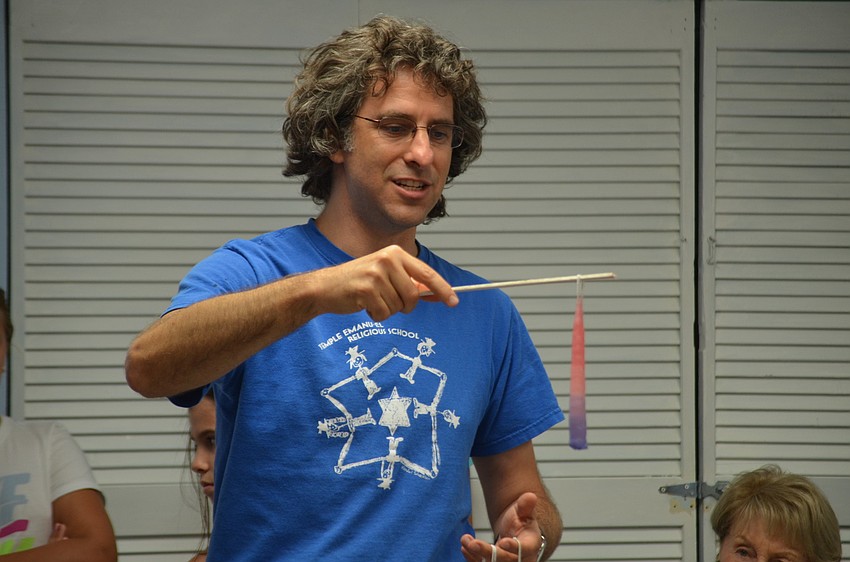 Rabbi Brenner Glickman teaches everyone how to make a candle.