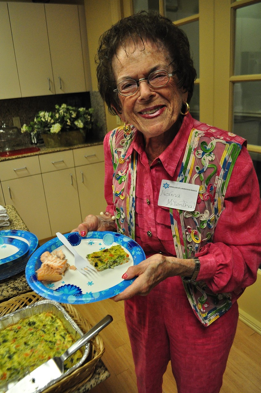 Norma Lee Mittenthal fills up her plate with a variety of kosher foods.