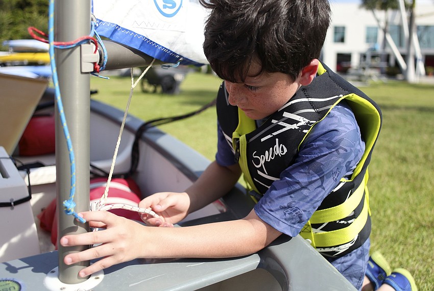 Cooper Kennedy, 9, ties a knot he has learned while at camp.