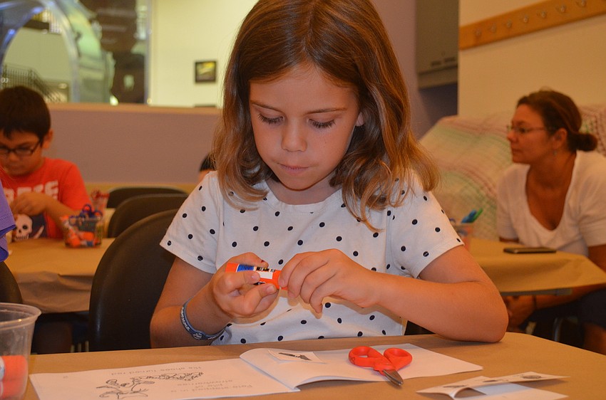 Maddie Bryer glues pages in the book.