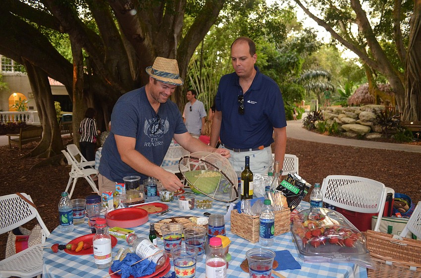 Chris Valcarcel and Charlie Bailey enjoy cheese from their family's table.